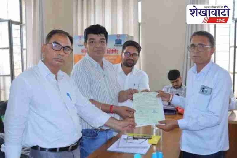 Manaram Meghwal holding his property card received under the Swamitva Yojana during the government camp in Seetsar village, Churu district