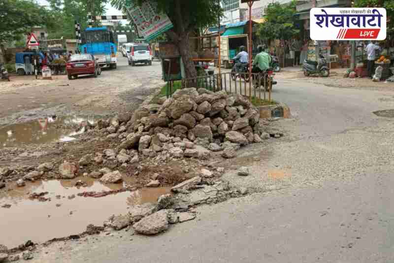 Damaged road with potholes and stagnant water at Hawai Patti Circle in Jhunjhunu
