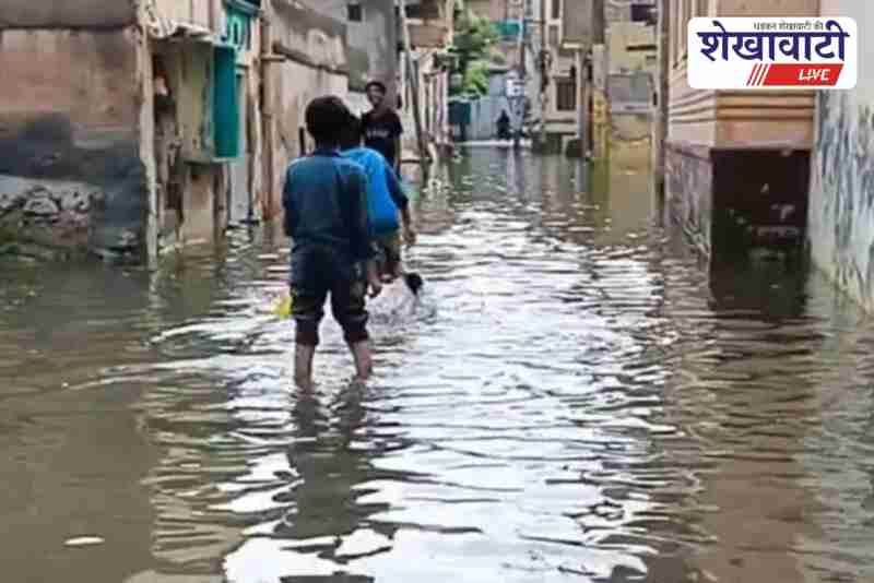 Children playing cricket in rainwater flooded neighborhood Churu