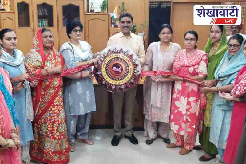 Women wing members tying rakhi to Jhunjhunu collector Arun Garg